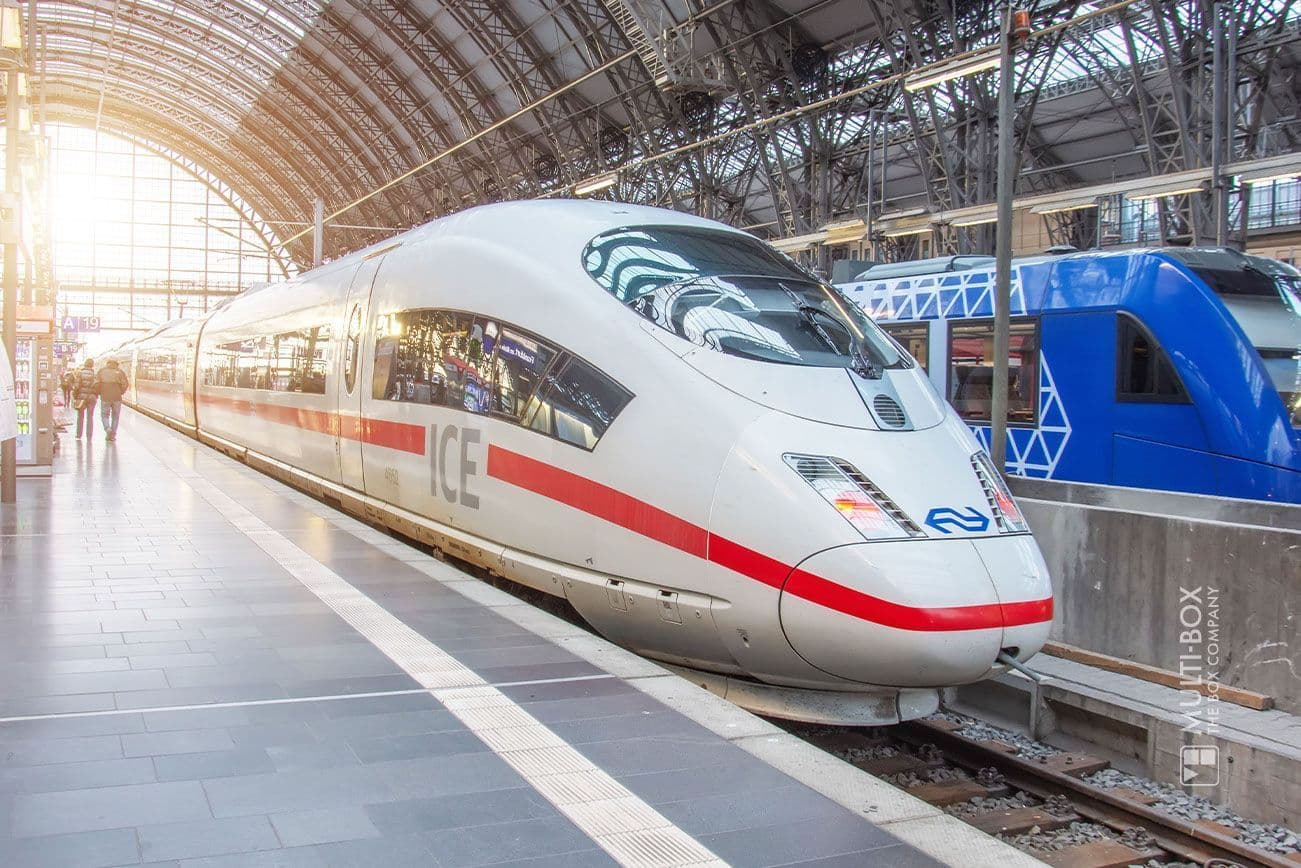 An ICE train is stationary at a station, illuminated by the morning light