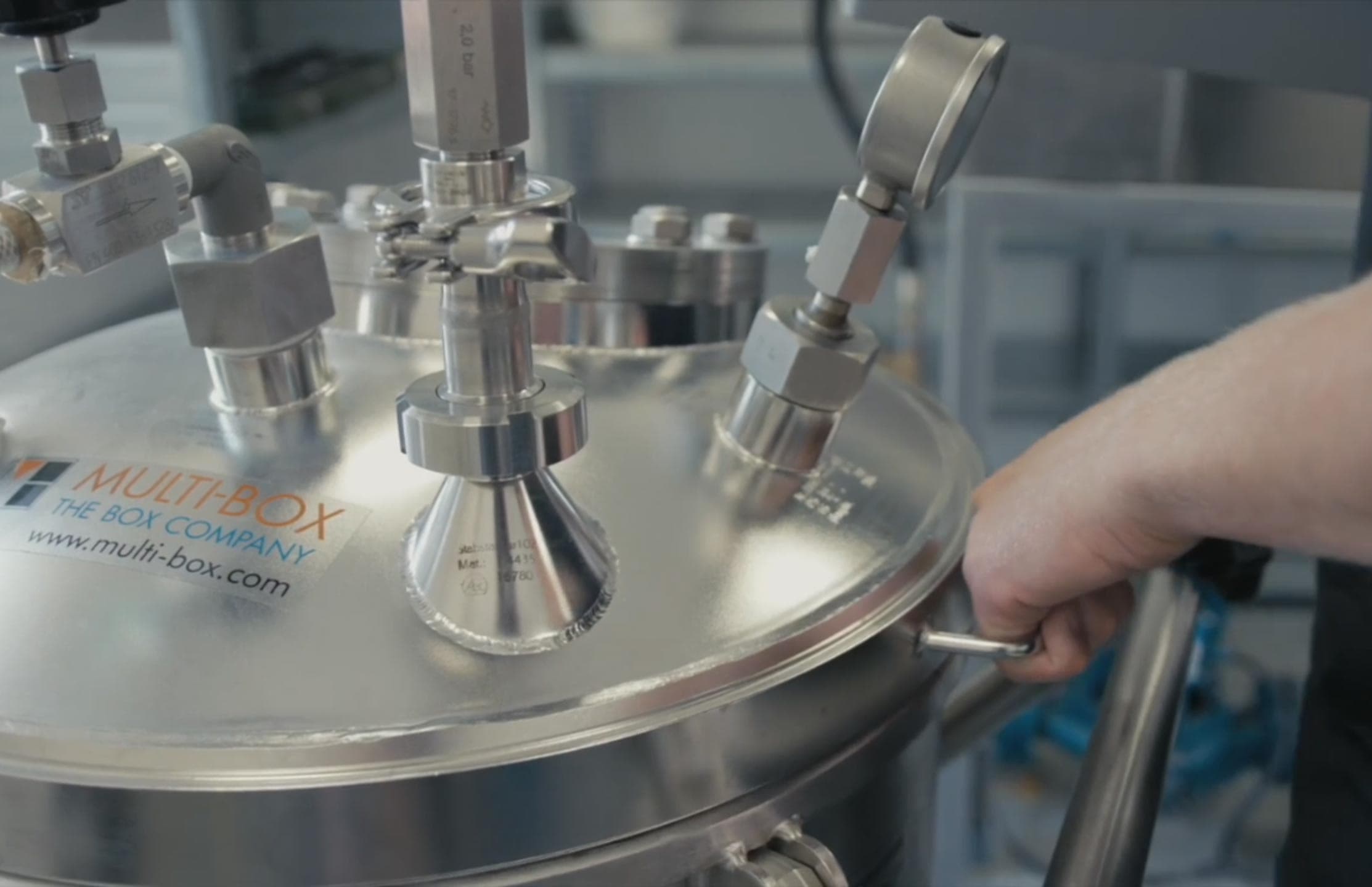 A stainless steel dip tank with several connections and hoses is used for leak tests.